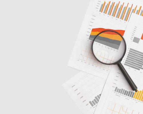 Business graphs, charts and magnifying glass on table. Financial development, Banking Account, Statistics